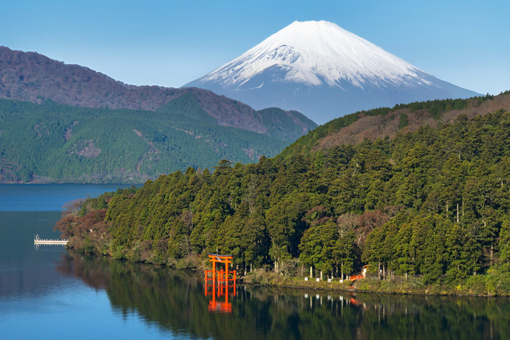 A mountain with a red torii gate in the foreground.